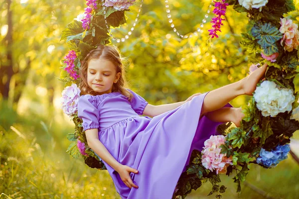 Menina bonito vestindo vestido lilás posando enquanto sentado em rin — Fotografia de Stock
