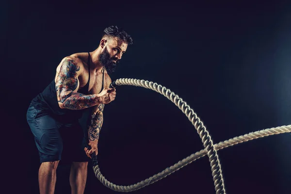 Muscular man working out with heavy rope. Photo of man with naked torso. Strength and motivation. — Stock Photo, Image