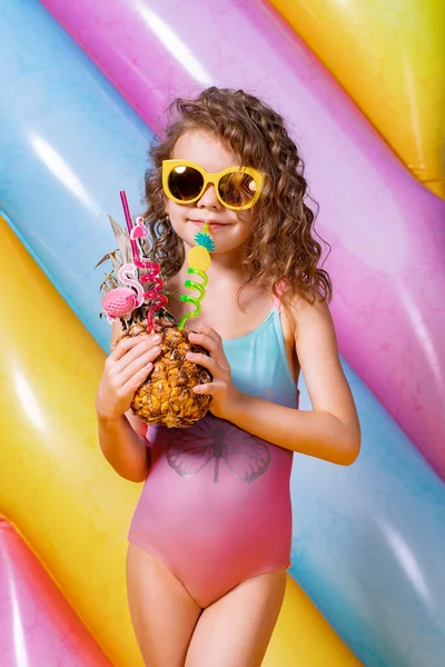 Ładna uśmiechnięta dziewczyna w różowych i niebieskich strojach kąpielowych i okularach przeciwsłonecznych — Zdjęcie stockowe