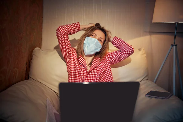 Joven mujer de negocios en una máscara de protección médica trabaja desde casa —  Fotos de Stock