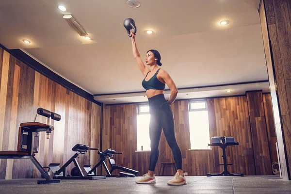 Jong volwassen fitness vrouw doen swing oefening met een kettlebell — Stockfoto