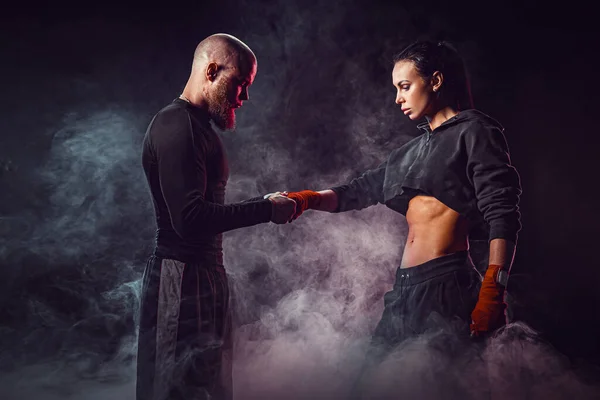 Mujer haciendo ejercicio con entrenador en la lección de boxeo y defensa personal — Foto de Stock