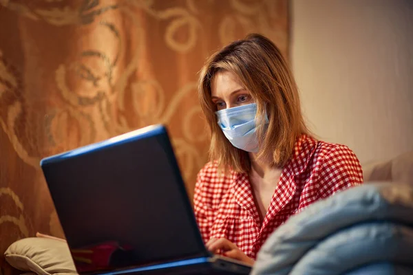 Jeune femme d'affaires dans un masque de protection médicale fonctionne à partir de la maison — Photo
