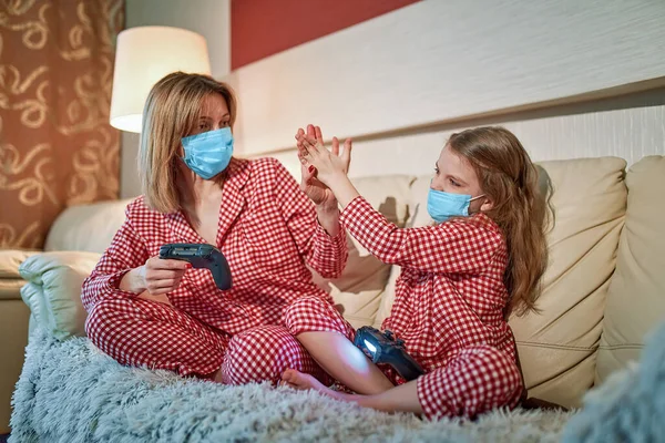 Kvinna och ung flicka bär pyjamas och medicinsk skyddsmask — Stockfoto
