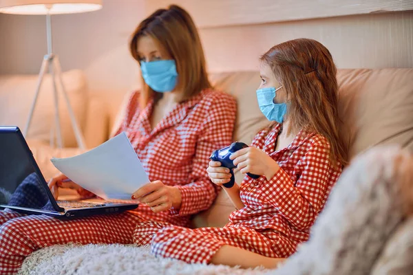 Kvinna i pyjamas med anteckningsbok och papper som arbetar hemifrån — Stockfoto