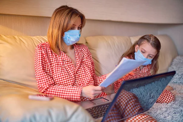 Kvinna i pyjamas med anteckningsbok och papper som arbetar hemifrån — Stockfoto