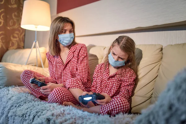 Kvinna och ung flicka bär pyjamas och medicinsk skyddsmask — Stockfoto