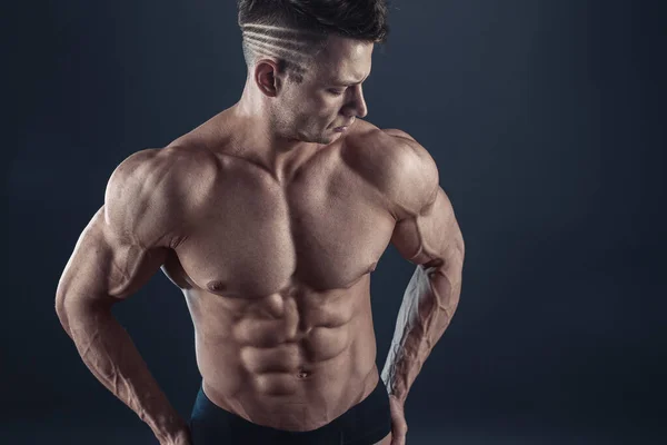 Stark atletisk sexig muskulös man på svart bakgrund — Stockfoto