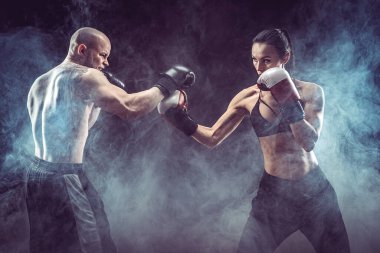Üstsüz kadın boks antrenörüyle egzersiz yapıyor ve kendini savunuyor.