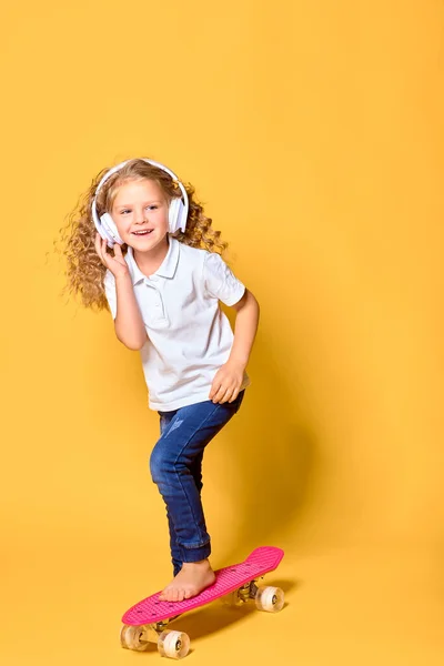 Active and happy girl with curly hair, headphones having fun wit