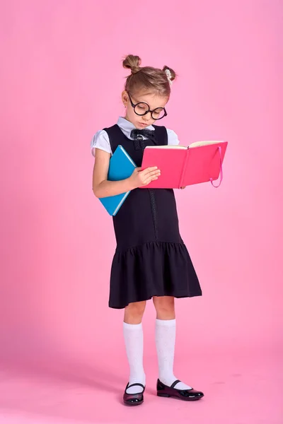 Χαριτωμένο κοριτσάκι με γυαλιά και βιβλία σε ροζ φόντο, spac — Φωτογραφία Αρχείου