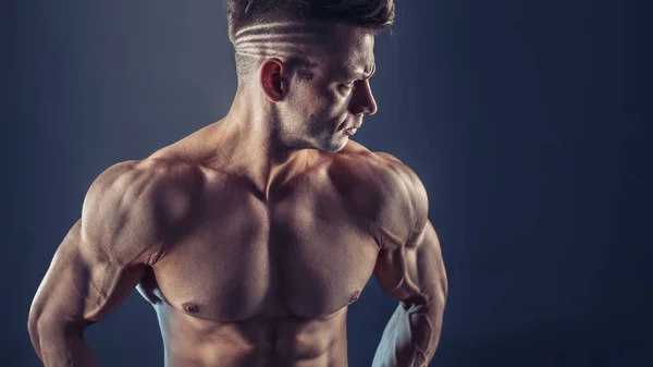 Hemdloser männlicher Bodybuilder mit muskulösem Körperbau, der starke Bauchmuskeln zeigt. Schuss eines gesunden, muskulösen jungen Mannes. Perfekte Passform, Sixpack, Bauchmuskeln, Schultern, Deltas, Bizeps, Trizeps und Brust — Stockfoto