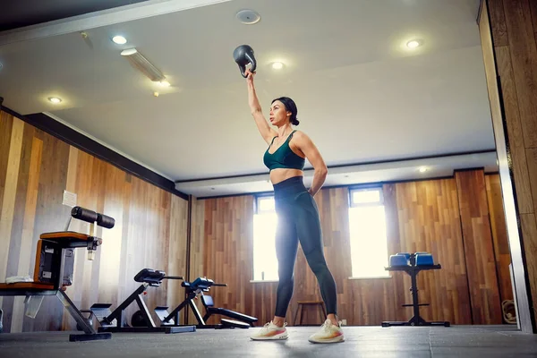 Jong volwassen fitness vrouw doen swing oefening met een kettlebell — Stockfoto