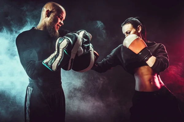Vrouw oefenen met trainer bij boksen en zelfverdedigingsles — Stockfoto
