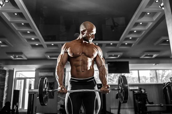 Muscular man working out in gym doing exercises with dumbbells at biceps, strong male naked torso abs — Stock Photo, Image