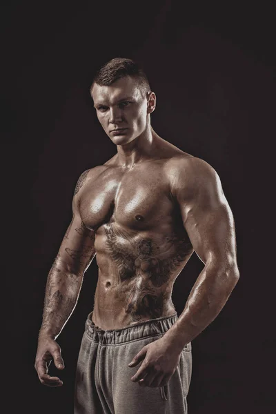 Estúdio retrato de um atlético sem camisa tatuado macho — Fotografia de Stock