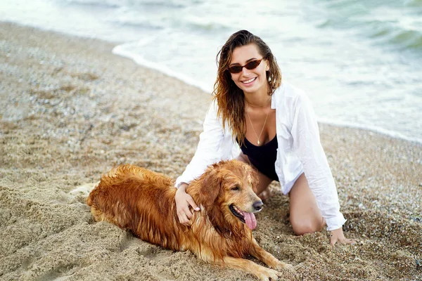 Портрет счастливой милой молодой женщины сидя и обнимая свою собаку о — стоковое фото
