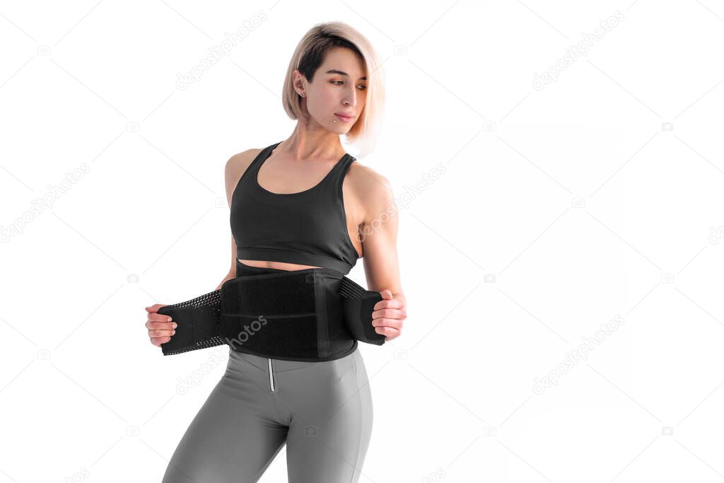Girl doing fitness back belt slimming isolated on white backgrou