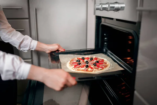 Rå pizza med ingredienser på bakplåt — Stockfoto