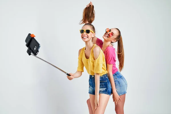 Retrato de adolescentes felices tomando selfie juntos aislados en blancoRetrato de adolescentes felices en ropa de verano, gafas de sol tomando selfie juntos aislados en blanco. — Foto de Stock