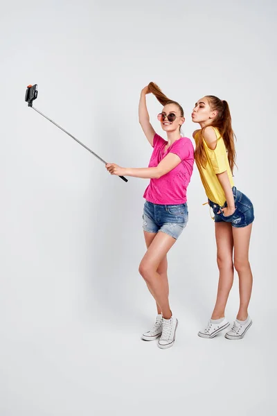 Portrét šťastných teenagerů se selfie společně izolované na bíléPortrét šťastných teenagerů v letních šatech, sluneční brýle přičemž selfie spolu izolované na bílém. — Stock fotografie