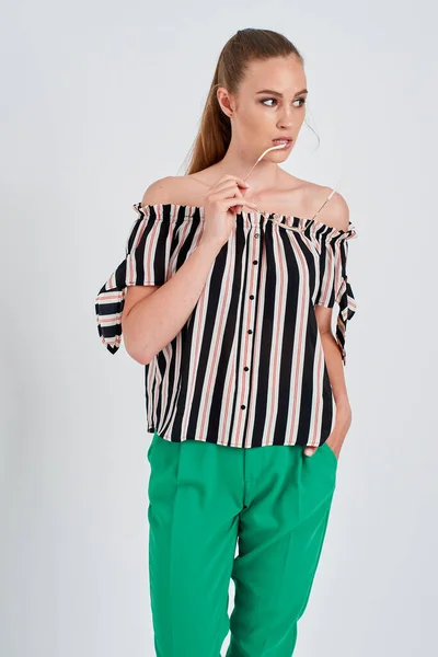 Bela menina em camisa listrada e calças verdes isoladas no fundo branco — Fotografia de Stock