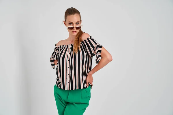 Bela menina em camisa listrada e calças verdes isoladas no fundo branco — Fotografia de Stock