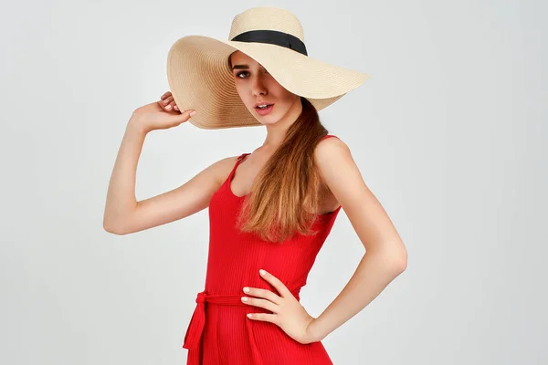 화실에서 전반적으로 우아 한 빨간색으로 흰 배경에 서 있는 아름다운 태양 모자를 쓴 소녀 — 스톡 사진