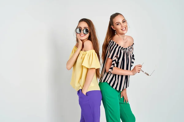 Two young women in stylish clothes fashion beauty studio shot on white background — Stock Photo, Image