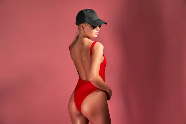 The back view of fit, healthy and sporty girl in swimsuit and cap at studio. Sport, fitness, diet and healthcare concept — Stock Photo, Image