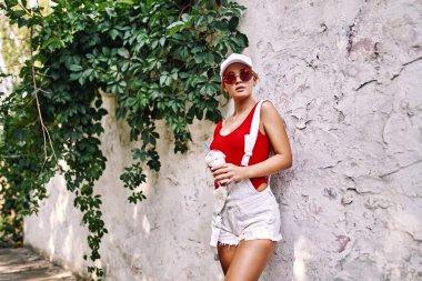 Mutlu gülümseyen genç kız bardakta içiyordu yaz parkında samanla.