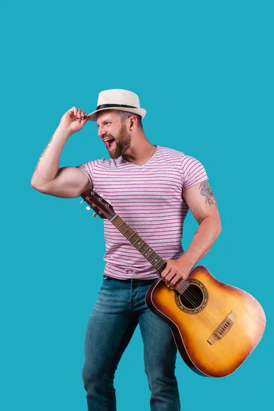 Handsome african american retro styled guitarist playing acoustic guitar isolated on blue background — Stock Photo, Image