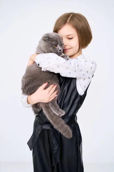 Маленькая белая девочка держит своего кота на руках — стоковое фото