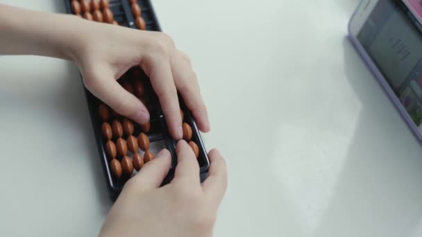 Дівчинка виконує арифметичні завдання на японських крупних рахунках. — стокове відео
