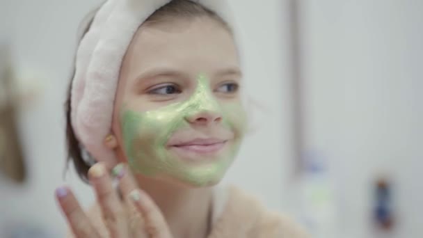 Mooi jong blank meisje mam toepassen gezicht masker op haar gezicht thuis — Stockvideo