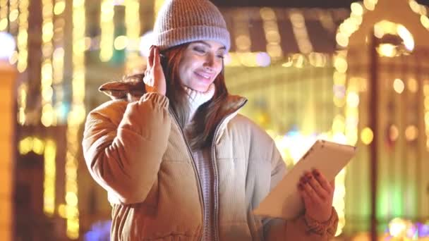 Γυναίκα σε χιονισμένη νύχτα χρησιμοποιώντας ψηφιακή ταμπλέτα στη χειμερινή πόλη — Αρχείο Βίντεο