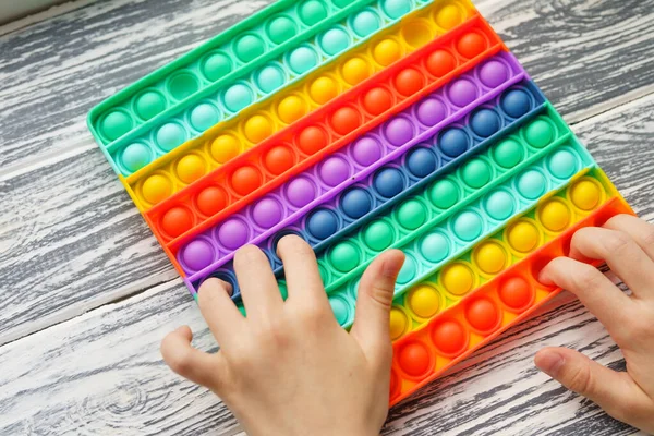 Trendy popular silicone colorful anti stress pop it toy . Close up. Someone push sensory popit. Trendy hype theme from tik tok — Stock Photo, Image