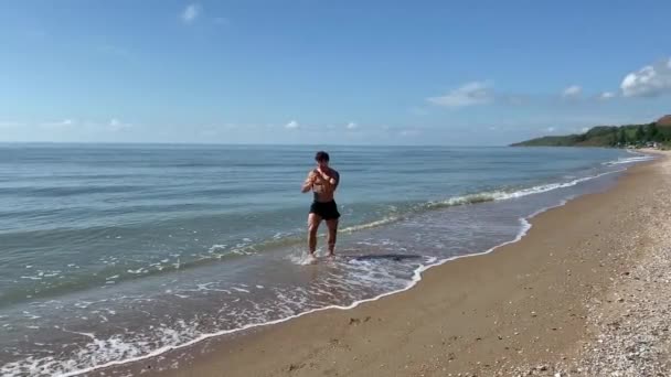 Homme tatoué boxeur de rue faisant de l'entraînement Se battre avec l'ombre au bord de la mer. Images 4k de haute qualité. Handheld — Video