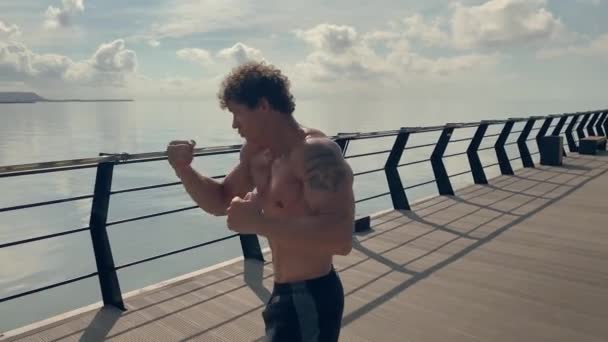 Getatoeëerde man Straatbokser doet workout training Vechten met schaduw. Hoge kwaliteit 4K beelden, slow motion. Handheld — Stockvideo