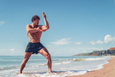 Muay Thai ya da kickboksör eğitimi deniz kenarında gölgeli boks eğitimi.