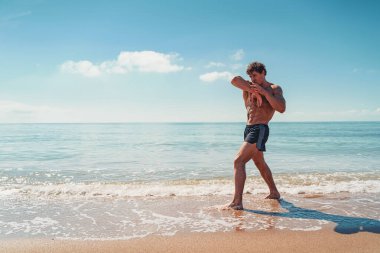 Muay Thai ya da kickboksör eğitimi deniz kenarında gölgeli boks eğitimi.