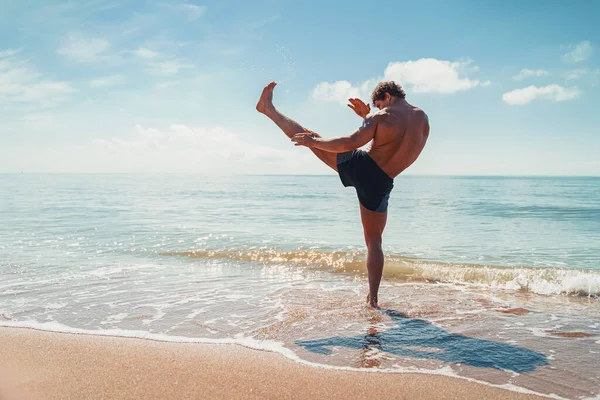 Un muay thai o kickboxer entrenando con boxeo de sombras al aire libre en la orilla del mar —  Fotos de Stock