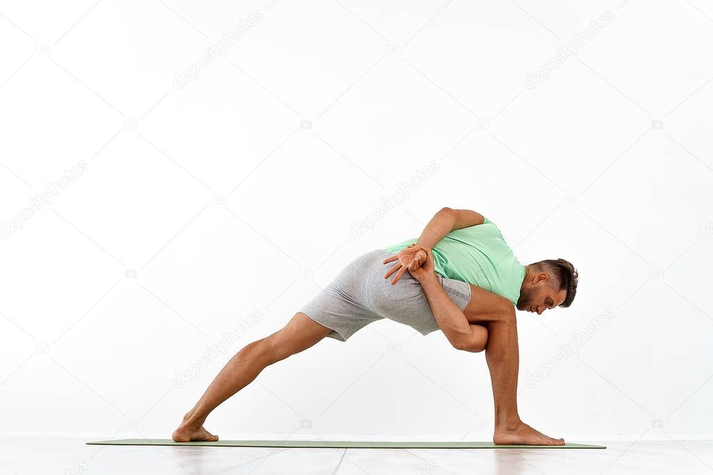 back view of sporty man practicing yoga in yoga class, making stretching back. Healthy lifestyle, Yoga Practice Exercise Class Concept