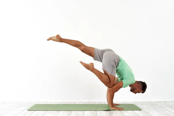 Man het beoefenen van saldo yoga pose op witte studio achtergrond — Stockfoto