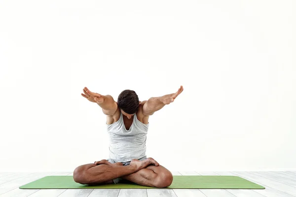 Yoga laki-laki menjadi gila dalam pose klasik di studio atas latar belakang putih — Stok Foto