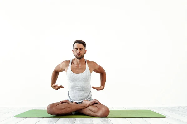 Yoga laki-laki menjadi gila dalam pose klasik di studio atas latar belakang putih — Stok Foto