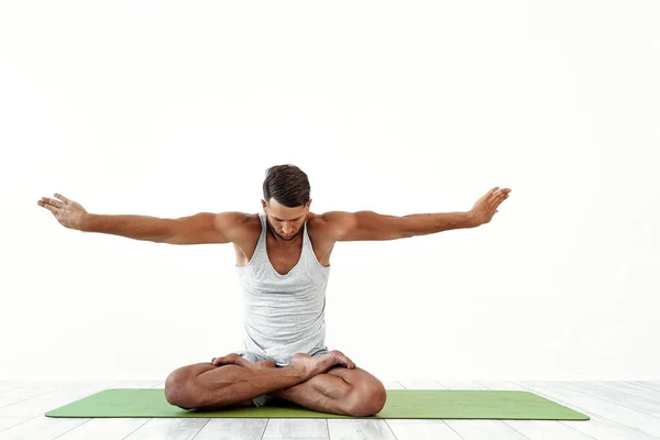 Yoga laki-laki menjadi gila dalam pose klasik di studio atas latar belakang putih — Stok Foto