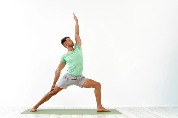 Pemuda yang menarik berlatih yoga tingkat lanjut di latar belakang putih. Serangkaian pose yoga. untuk kesehatan yang baik. Olahraga, meditasi dan konsep gaya hidup — Stok Foto