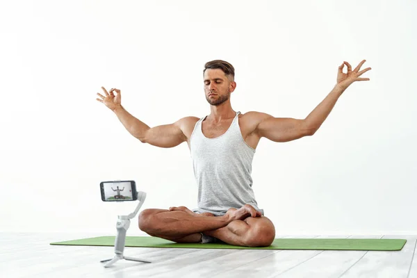 Fit blanke man opnemen van een blog of streaming yoga workout. — Stockfoto