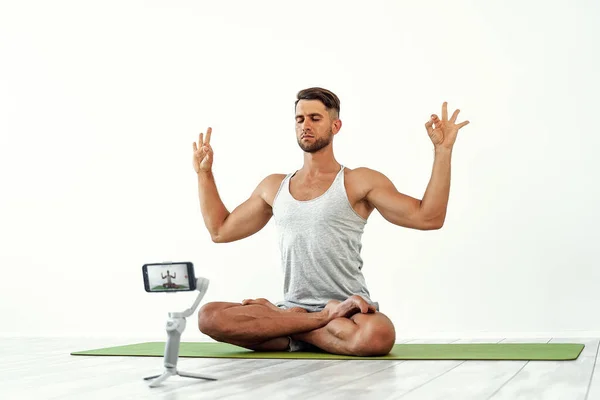 Fit blanke man opnemen van een blog of streaming yoga workout. — Stockfoto